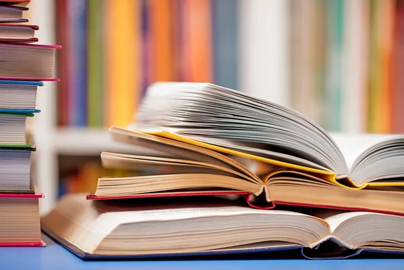 Bücherstapel mit aufgeklappten Büchern